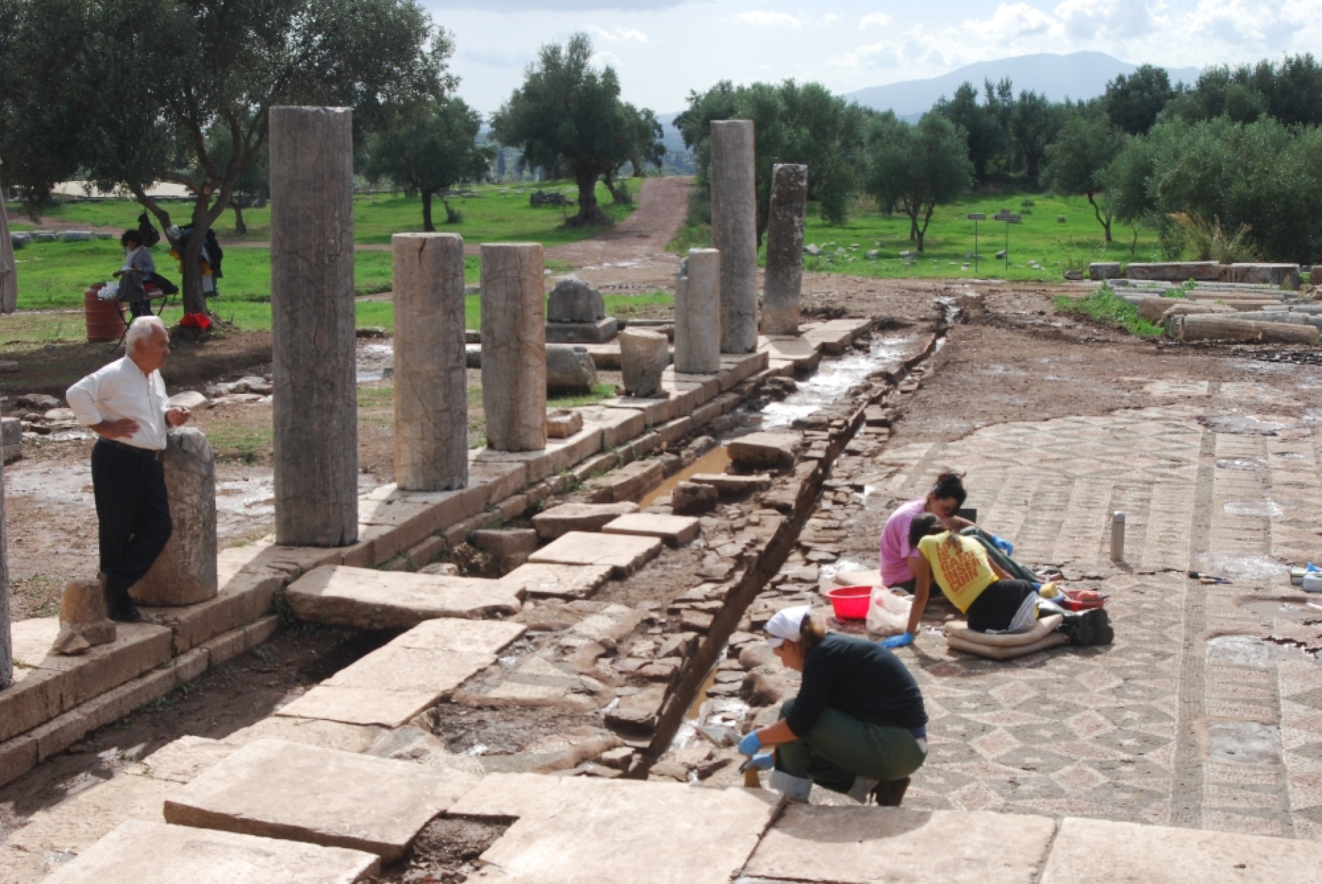 Ο Πέτρος Θέμελης επιτηρεί τις εργασίες στο ψηφιδωτό δάπεδο με τα γεωμετρικά θέματα, μπροστά στη  Στοά του Κρεοπωλείου