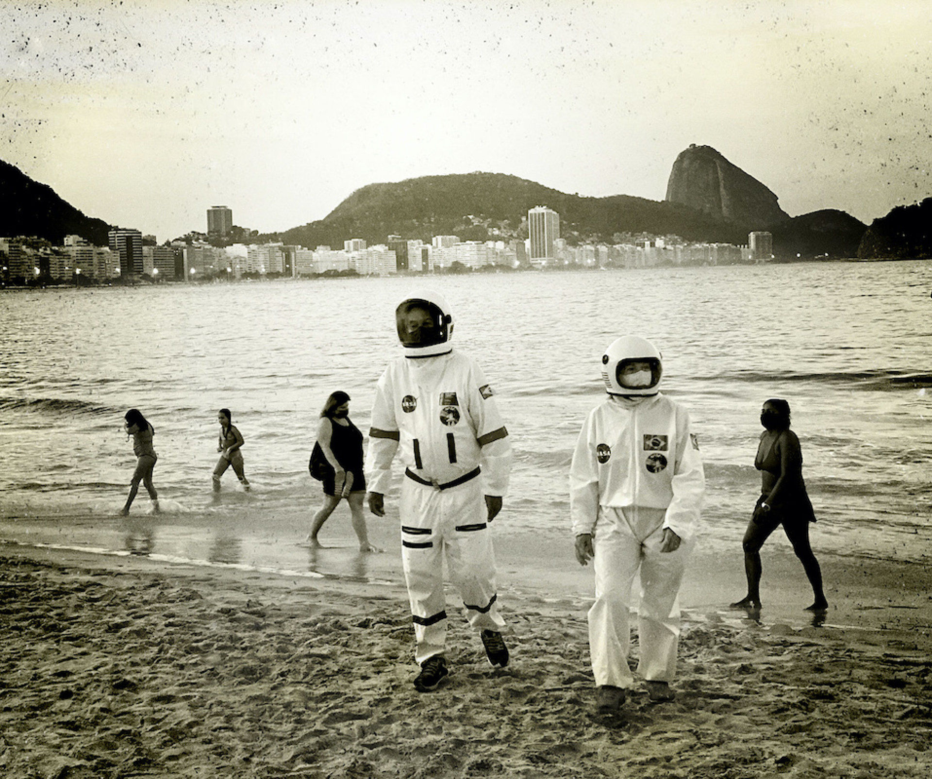 Ana Carolina, Fernandes Στην Παραλία Copacabana, ένα ζευγάρι, ο Tercio και η Alicea, και οι δύο 66 ετών και σε ομάδα υψηλού κινδύνου, φορούν ενδυμασία που θυμίζει αστροναύτη, την οποία σχεδίασαν για να προστατευτούν κατά του κορονοϊού ώστε να περπατούν ασφαλείς στην πόλη. Περιέργως, ο Υπουργός Επιστήμης και Τεχνολογίας -που ήταν όντως αστροναύτης- δεν έχει εμφανιστεί δημόσια για μήνες.
