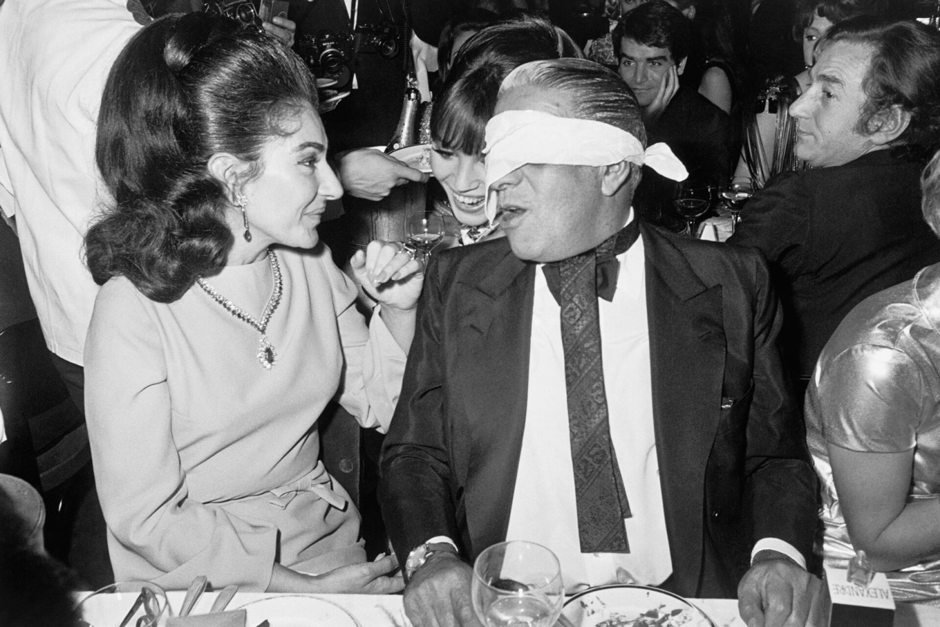 Η διάσημη σοπράνο όπερας, Μαρία Κάλλας, και ο Έλληνας μεγιστάνας επιχειρήσεων, Αριστοτέλης Ωνάσης, απολαμβάνουν μια βραδινή έξοδο στο Lido του Παρισιού. Η σχέση τους, που ξεκίνησε το 1959, καλύφθηκε από τον Τύπο σε όλο τον κόσμο