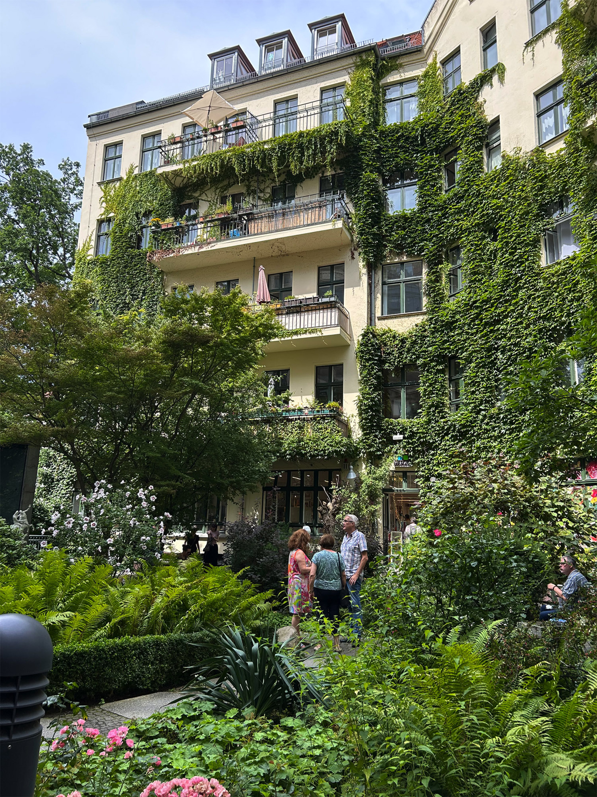 Στις πίσω αυλές των Hackesche Höfe το σκηνικό αλλάζει∙ λιγότεροι τουρίστες, περισσότερη γειτονιά. Κισσοί, κήποι και μπαλκόνια γεμάτα ζωή θυμίζουν ότι εδώ ζουν ακόμη Βερολινέζοι.