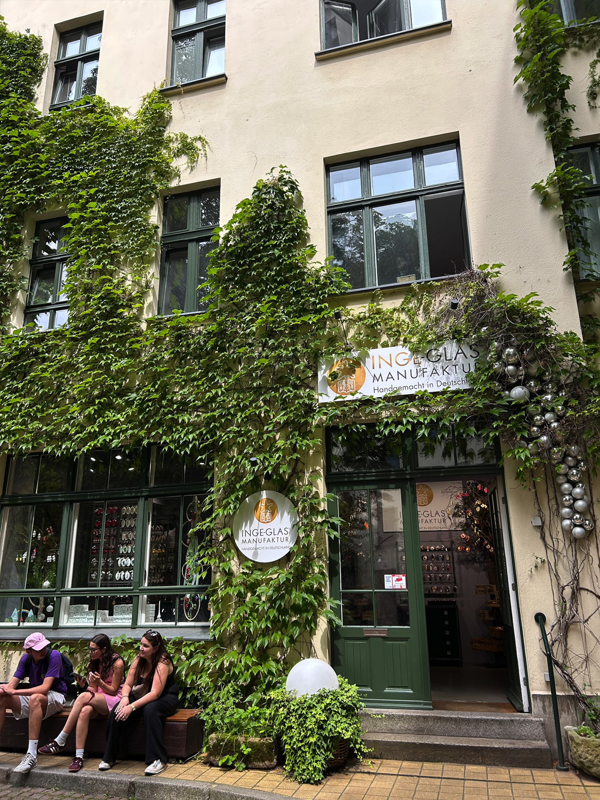 Μικρά μαγαζιά στις αυλές – καταστήματα με χειροποίητα αντικείμενα και παραδοσιακές δημιουργίες, ανάμεσα σε κισσούς και παλιές προσόψεις