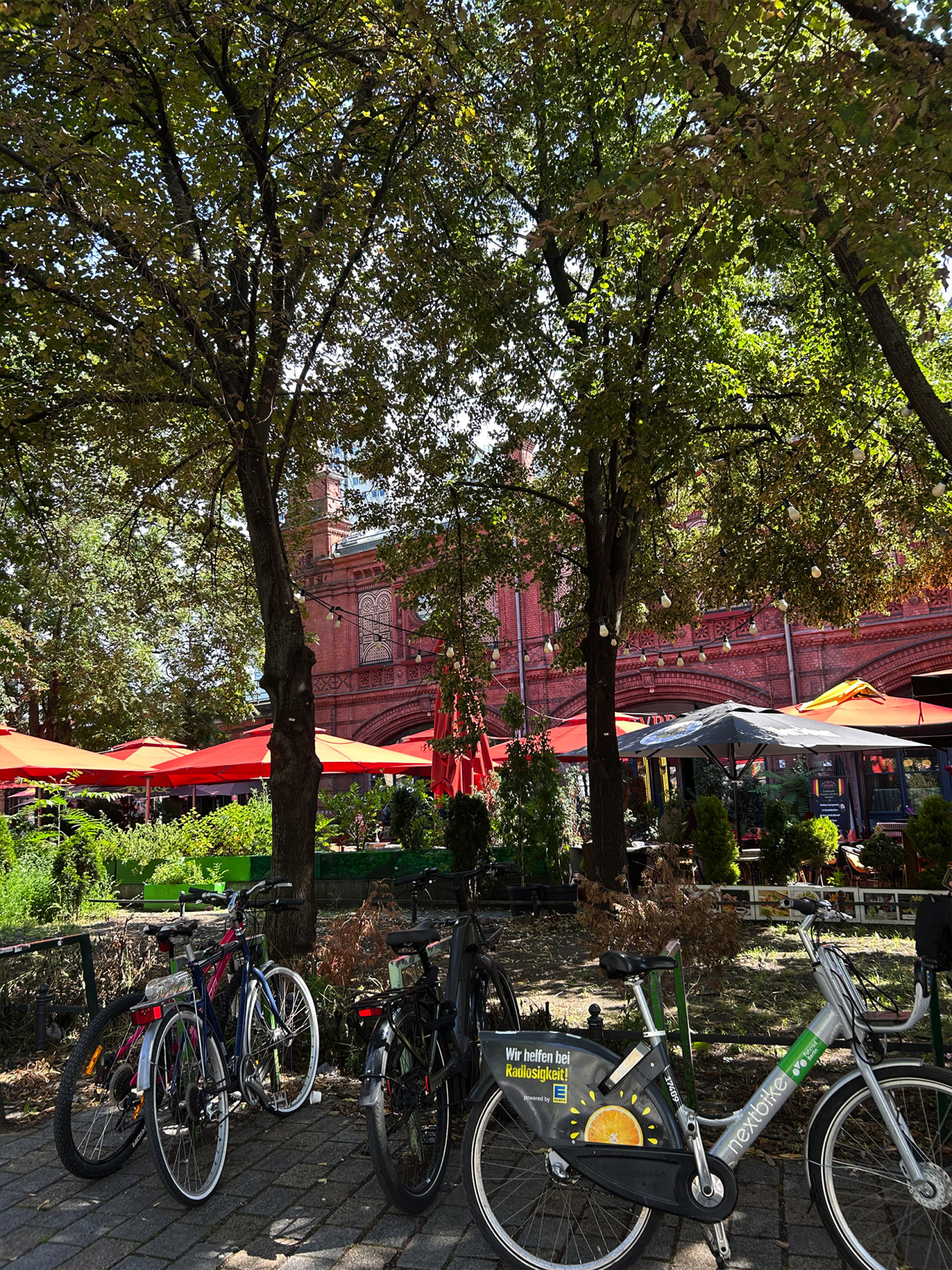 Στην Hackescher Markt, μπροστά στο κόκκινο κτίριο του σταθμού, ποδήλατα, καφέ και street food γεμίζουν την πλατεία με ζωή∙ κάθε Σαββατοκύριακο στήνεται υπαίθρια αγορά με πάγκους και μουσικούς του δρόμου.