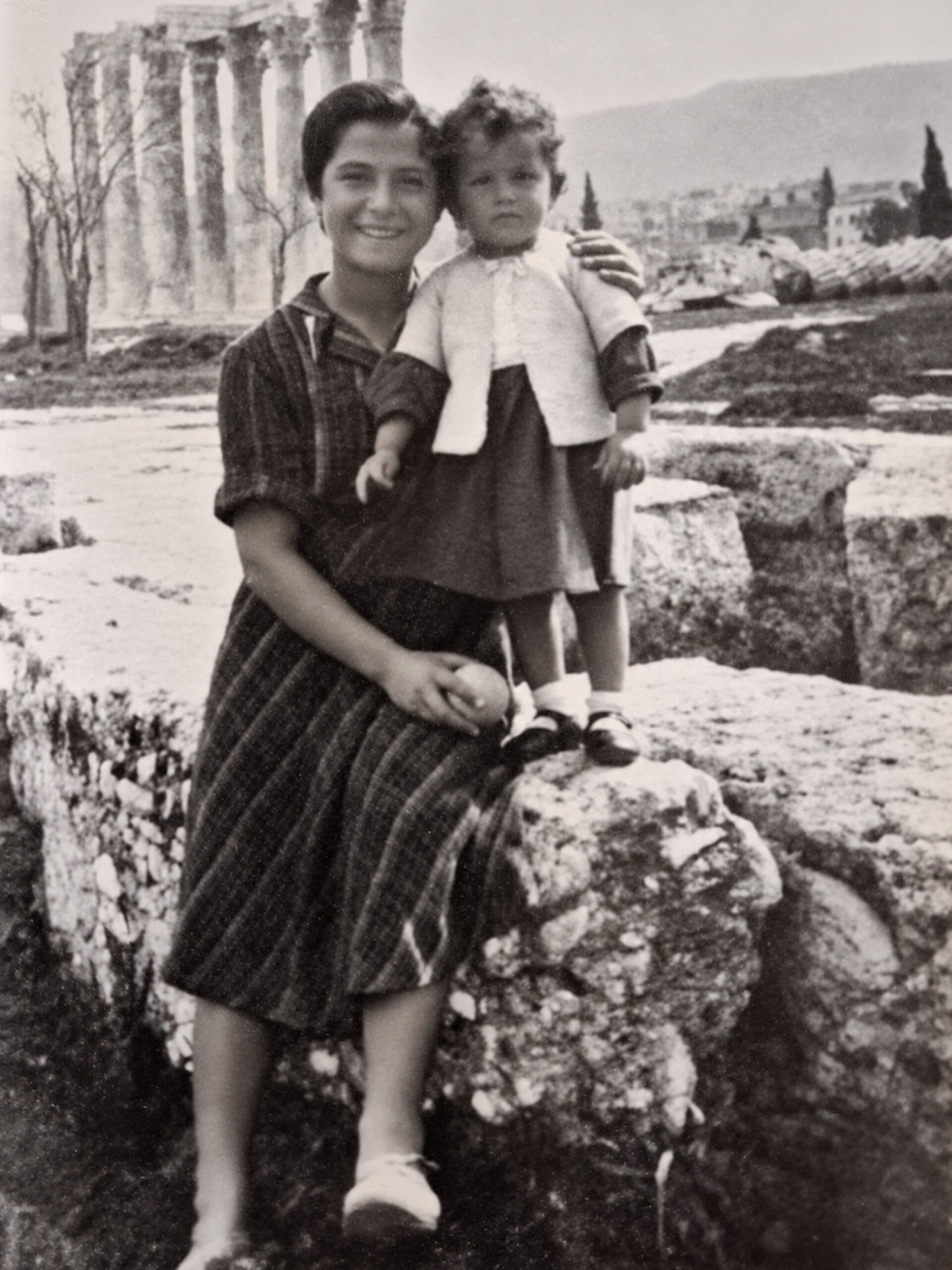 Η Δωροθέα Χάρου, που έφυγε από τη Λήμνο σε ηλικία 14 ετών για να γίνει ψυχοκόρη σε οικογένεια στο Μετς, σε βόλτα με τη μικρή κόρη της οικογένειας, Δέσποινα Δογάνη, στους Στήλους του Ολυμπίου Διός, το 1949-1950