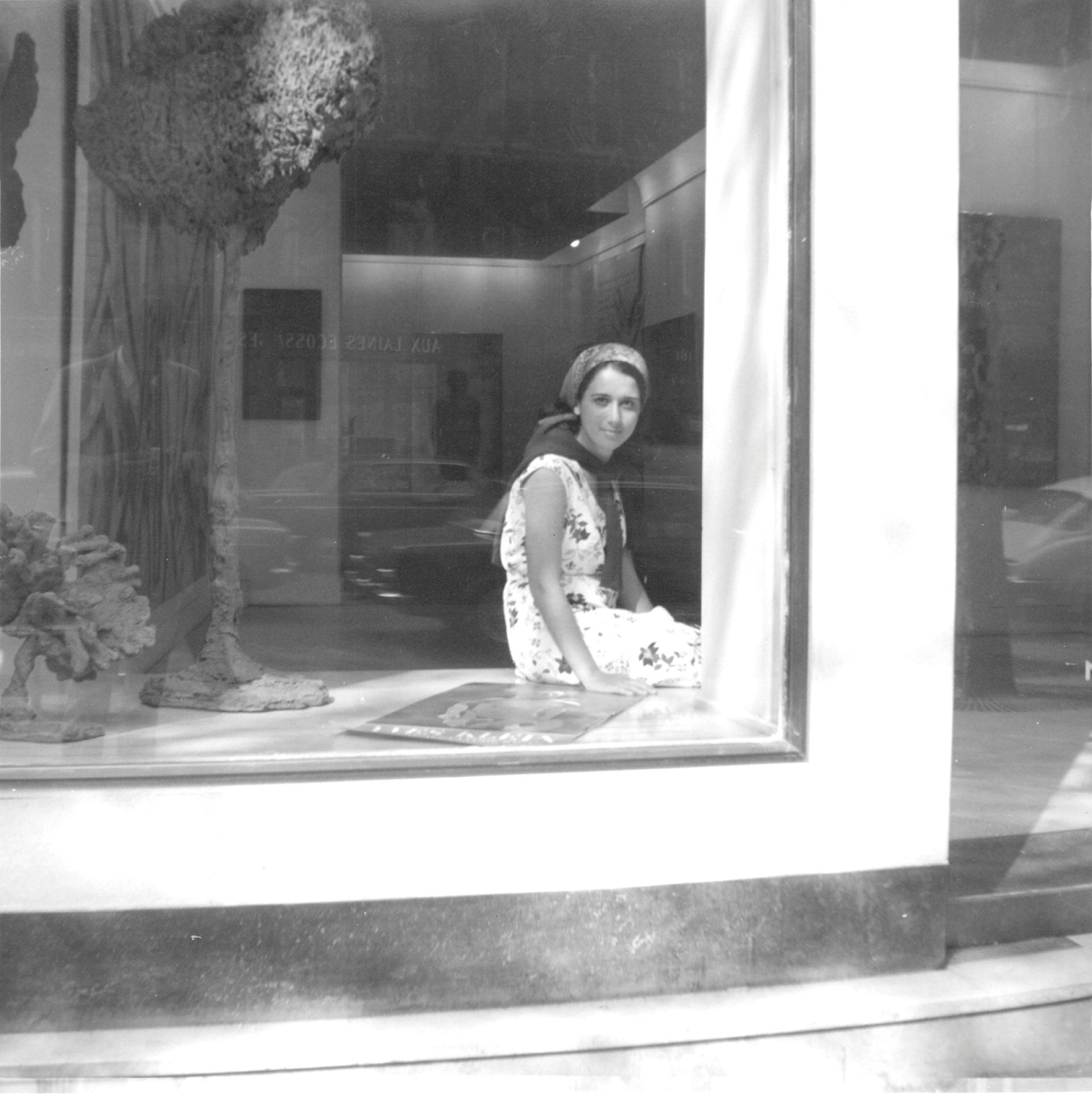 Η συγγραφέας  Ελένη Κουτσούδη-Ιόλα στη βιτρίνα της γκαλερί του Παρισιού, 196 Bd Saint Germain, το 1964 (αρχείο Ε.Κ.Ι.)