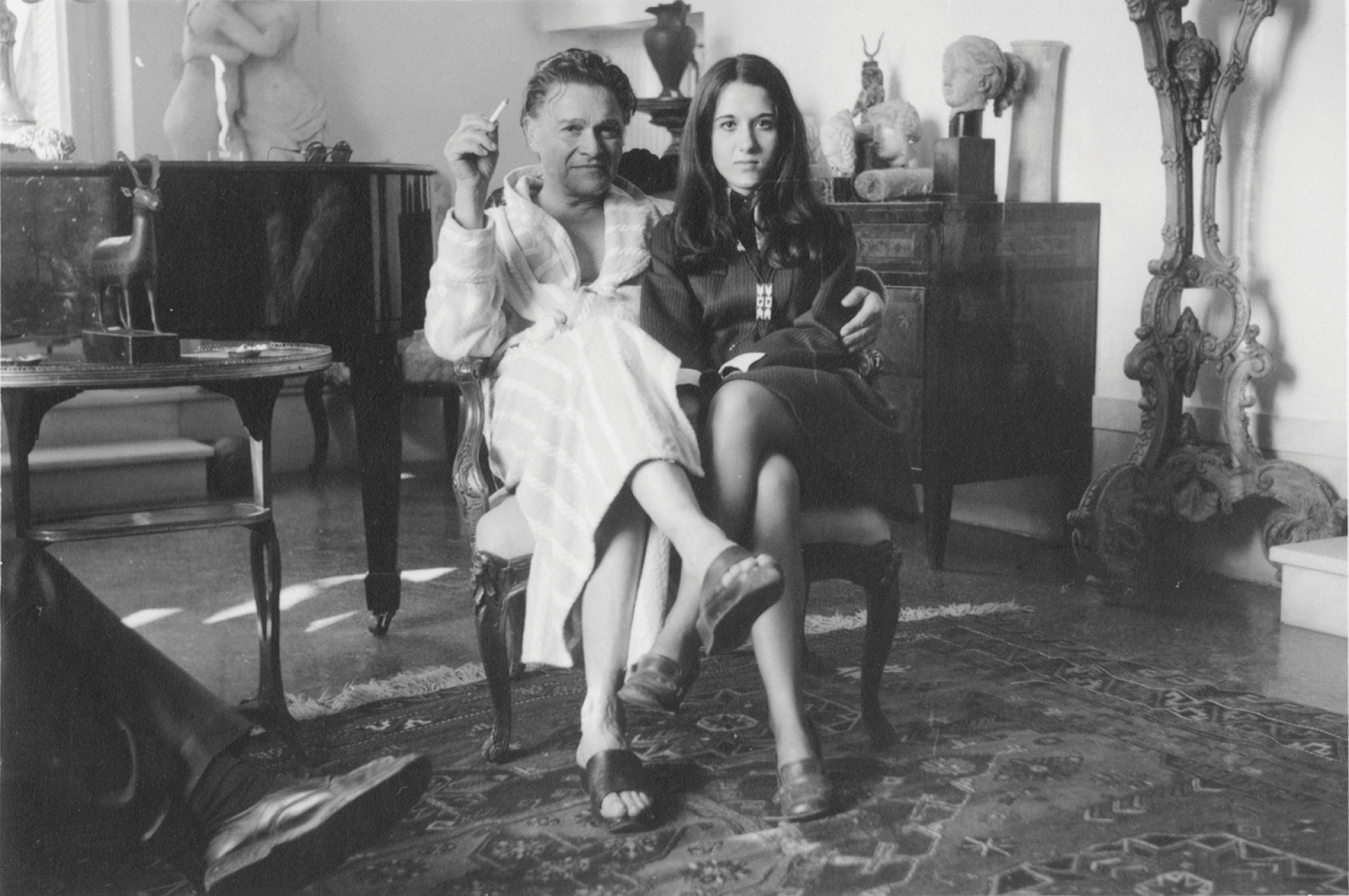 Αλέξανδρος Ιόλας και Ελένη Κουτσούδη-Ιόλα στο σαλόνι του πρώτου. Πίσω αριστερά, το αγαπημένο του πιάνο (αρχείο Ε.Κ.Ι.)