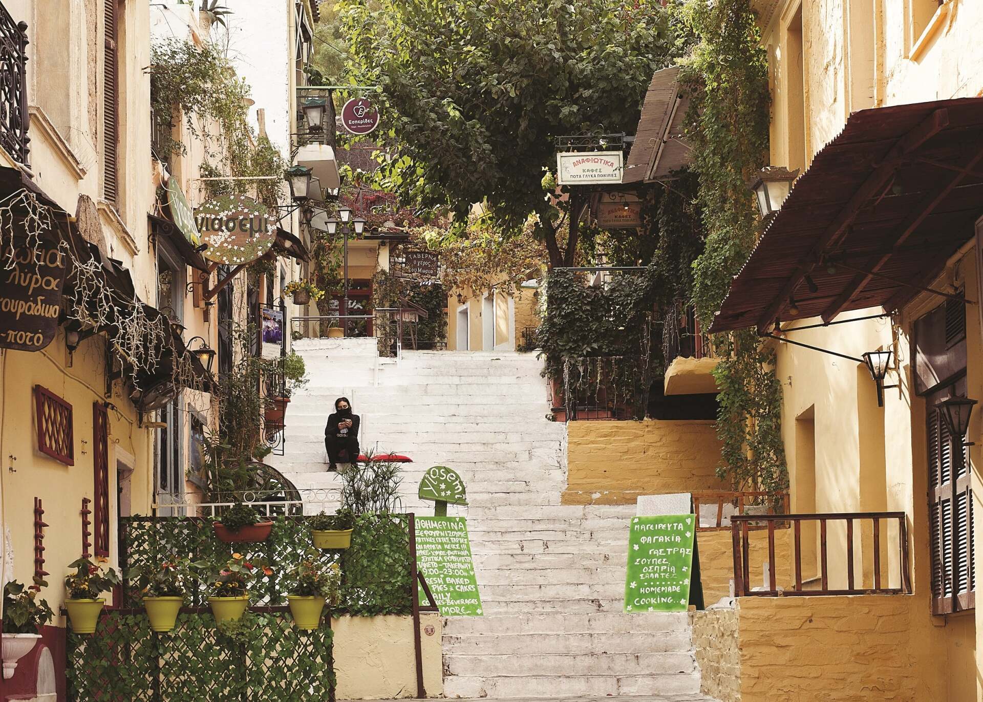 Γυναίκα με μάσκα που κάθεται σε σκαλιά στην περιοχή Αναφιώτικα στην Αθήνα κατά την περίοδο του lockdwon