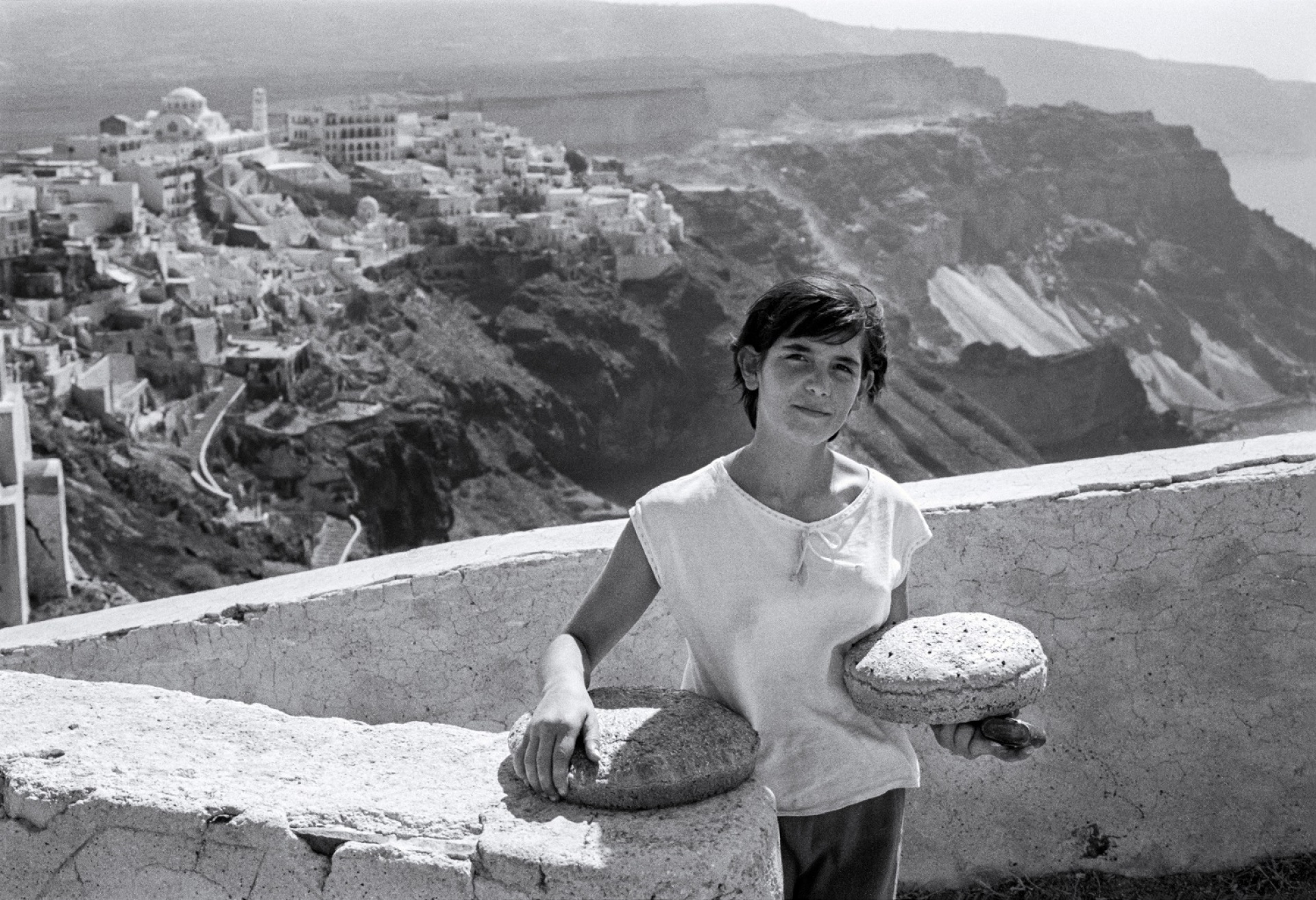 Σαντορίνη. Η Καλλιόπη Μουδάτσου επιστρέφοντας από το φούρνο, στην Καθολική γειτονιά με θέα τα Φηρά. ©ROobert McCabe