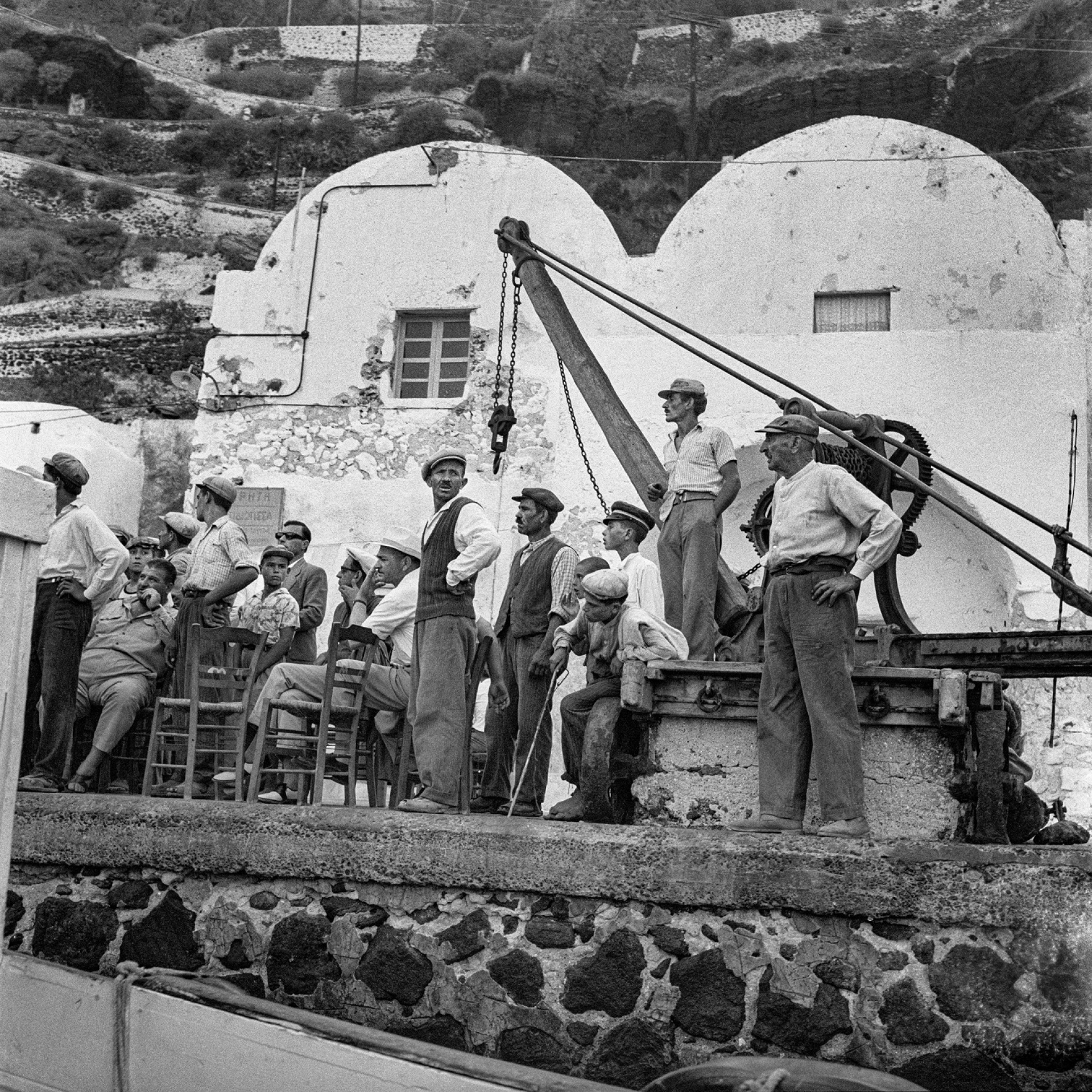 Σαντορίνη. Λιμενεργάτες ανάμεσα σε μουλαράδες και ταξιδιώτες στο καφενείο που είχε ο Μανώλης του «Άρμπουνα» στην αποβάθρα στον Γιαλό ©Robert McCabe