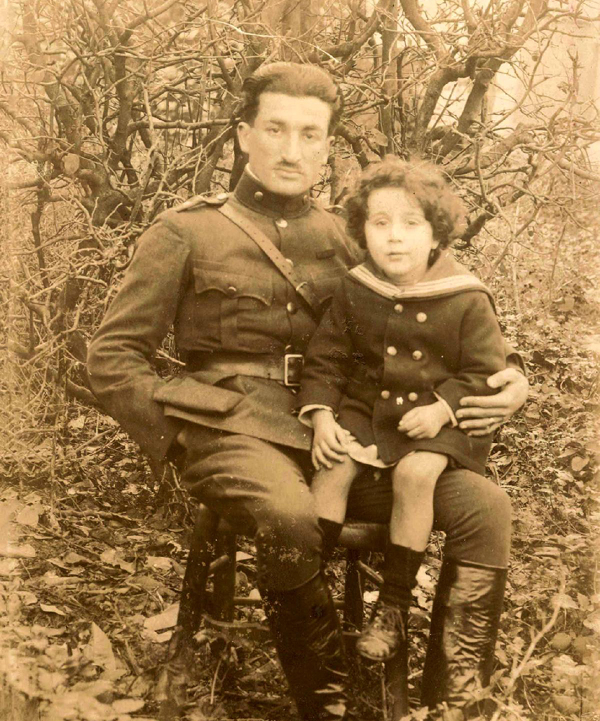 Ο Γιάννης Μόραλης στα πόδια του θείου του, Θρασύβουλου Τσακαλώτου, περ. 1920