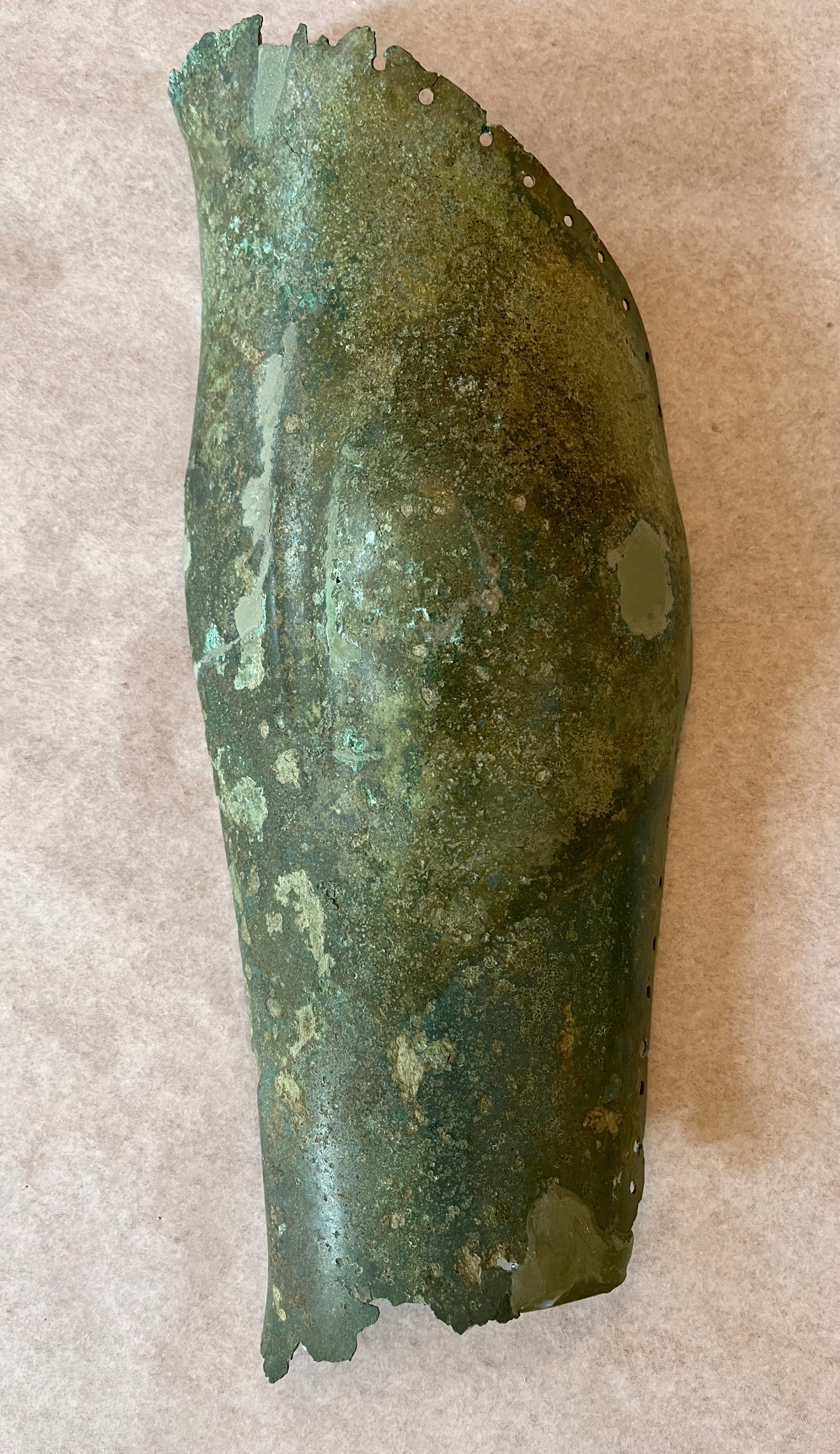 Χάλκινη περικνημίδα με οπές στο άνω μέρος για τη στερέωση της εσωτερικής επένδυσης. Κλασικών χρόνων