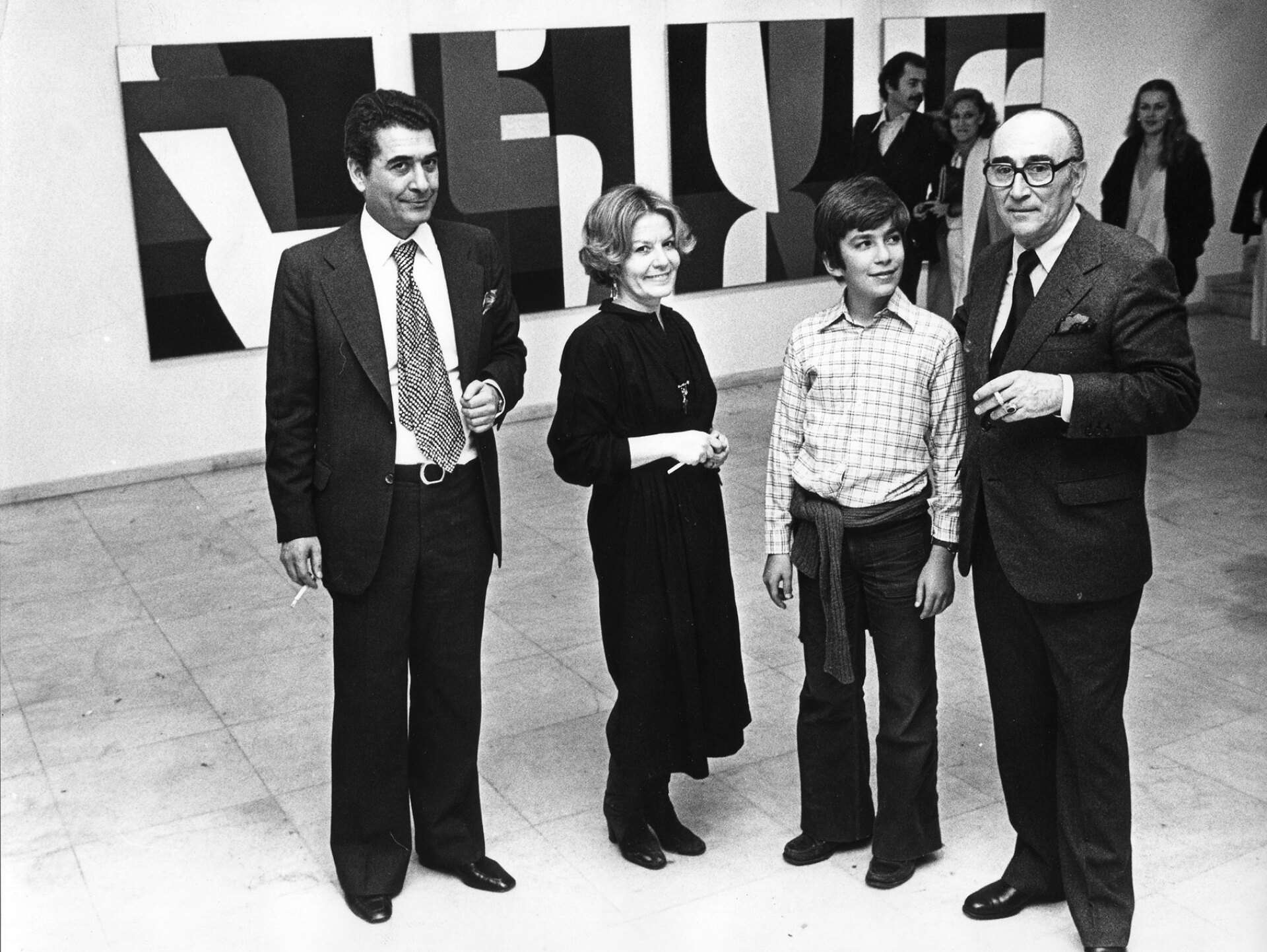 ￼Μάρτιος 1978. Μεγάλη αναδρομική στον Γιάννη Μόραλη. Από αριστερά: Τάσος και Πέγκυ Ζουμπουλάκη, με το γιο τους Θοδωρή και τον Μόραλη. Ο Μόραλης δεν υπήρξε απλώς συνεργάτης τους. Τους συνέδεε μια μακριά στενή φιλία που κράτησε μέχρι το θάνατο του καλλιτέχνη. Τον θυμούνται να ζωγραφίζει πάντα με στρογγυλά πινέλα. Όταν πέθανε, η Πέγκυ έδωσε μάχη για να μην πουληθεί σε ιδιώτη το εκπληκτικό σπίτι που διέθετε στην Αίγινα, έργο του αρχιτέκτονα Άρη Κωνσταντινίδη.