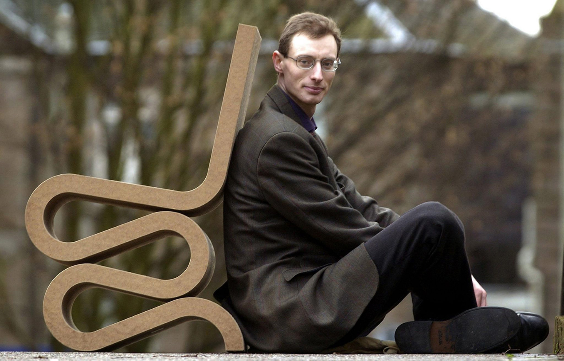 Ο επιμελητής Mathew Jarron καθισμένος στην καρέκλα «Wiggle Side» που σχεδίασε ο Frank Gehry  © EPA/ANDREW MILLIGAN UK AND IRELAND OUT