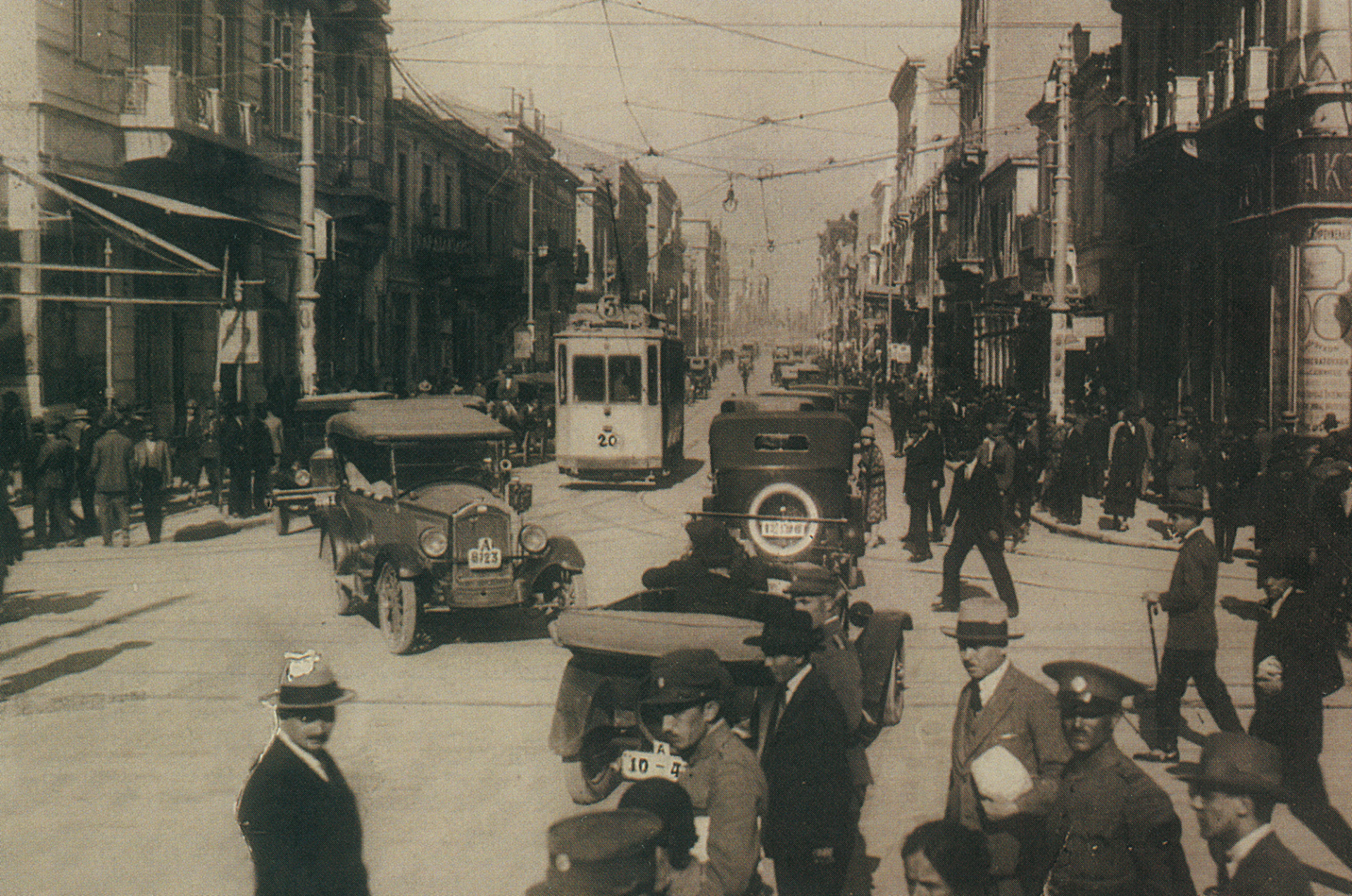 Άποψη της Αιόλου στα πρώτα χρόνια του 20ού αιώνα. Τη γαλήνη του δρόμου δεν έχουν ακόμα διαταράξει οι θορυβώδεις «τετράτροχοι δαίμονες», όπως αποκαλούσαν οι Αθηναίοι τα πρώτα αυτοκίνητα που εμφανίστηκαν στην πόλη.