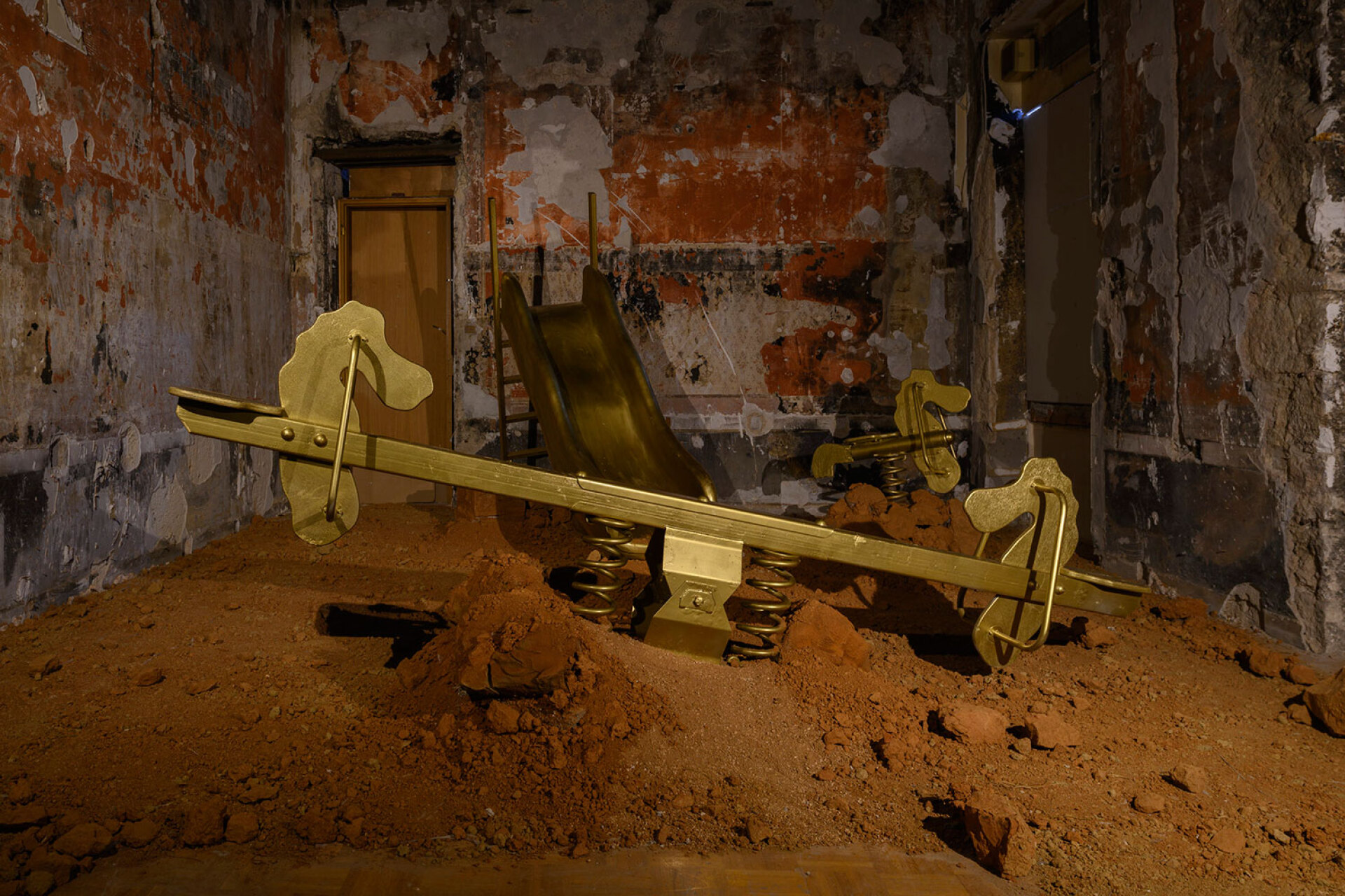 Αντα Πετρανάκη - Ιn search of lost time. ευρεθέντα αντικείμενα (τραμπάλα, κούνια, ελατήριο, τσουλήθρα), σίδερο, ξύλο, πλαστικό, χρυσό ακρυλικό χρώμα, ρευστό λευκό σμπάλτο, κοκκινόχωμα , διαστάσεις μεταβλητές. © © Χρίστος Σιμάτος