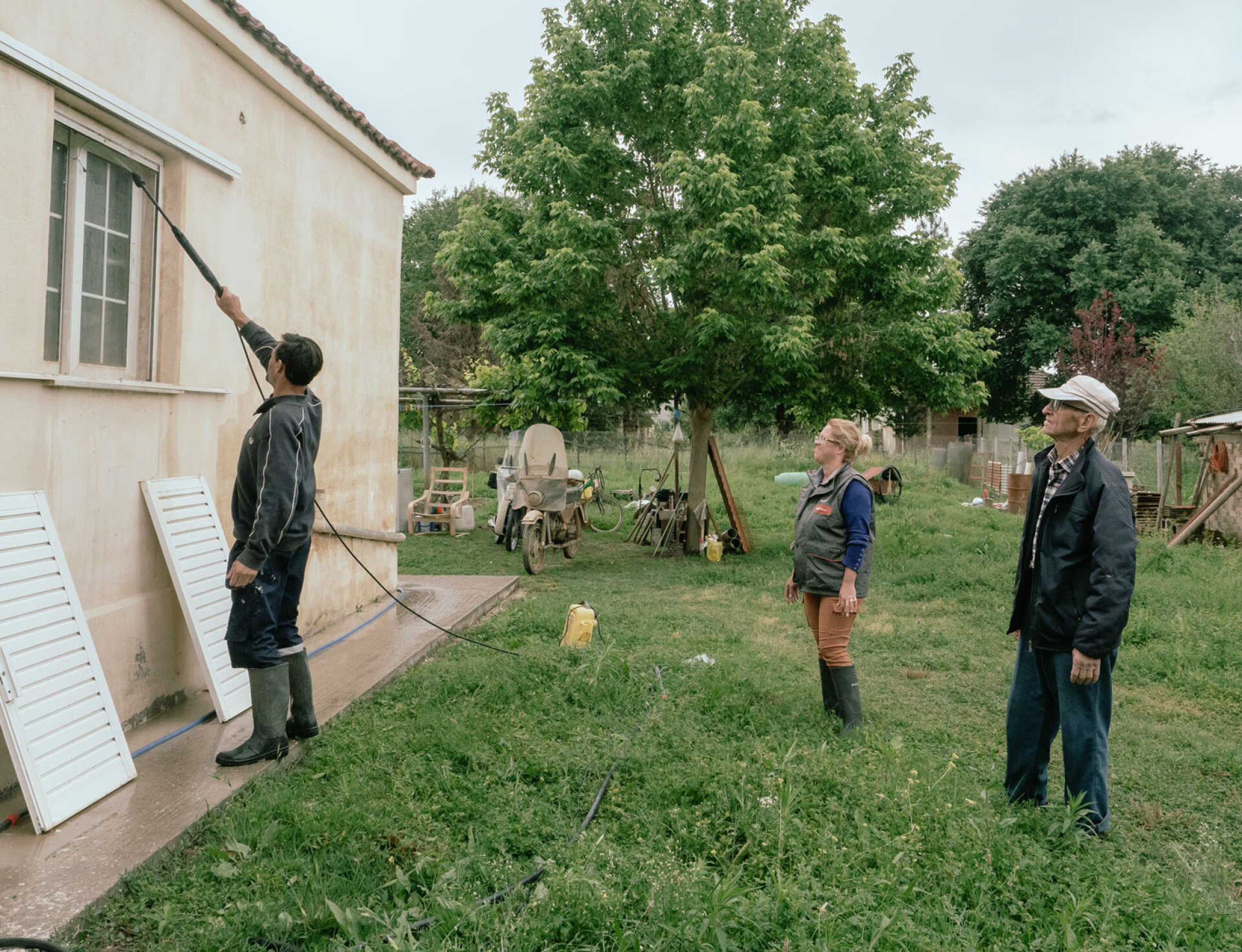 Στο χωριό Μεταμόρφωση οι κάτοικοι καθαρίζουν τους εξωτερικούς τοίχους που λερώθηκαν από τις πλημμύρες