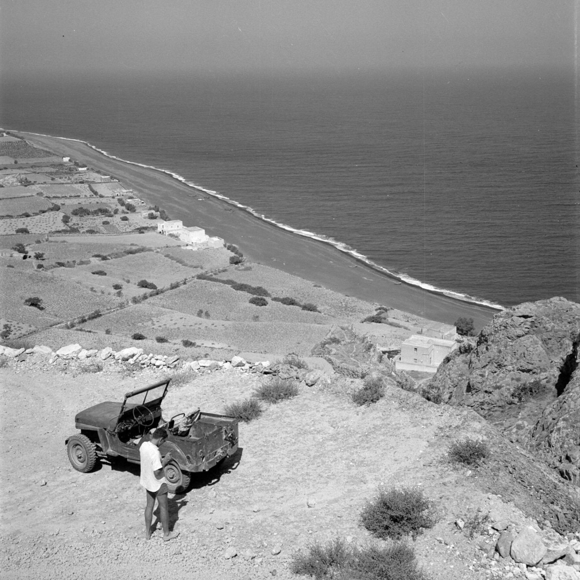 Σαντορίνη, το τζιπ του Αντενάουερ στο δρόμο που χτίστηκε για  ν’ ανέβει στην Αρχαία Θήρα. Τα χωράφια στη φωτογραφία είναι τώρα το Καμάρι