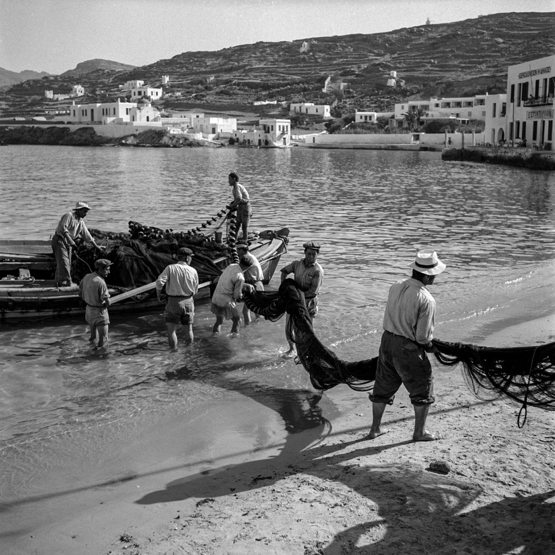  Μύκονος, 1955. Ψαράδες ξεφορτώνουν δίχτυα στη σκάλα του Καμπάνη