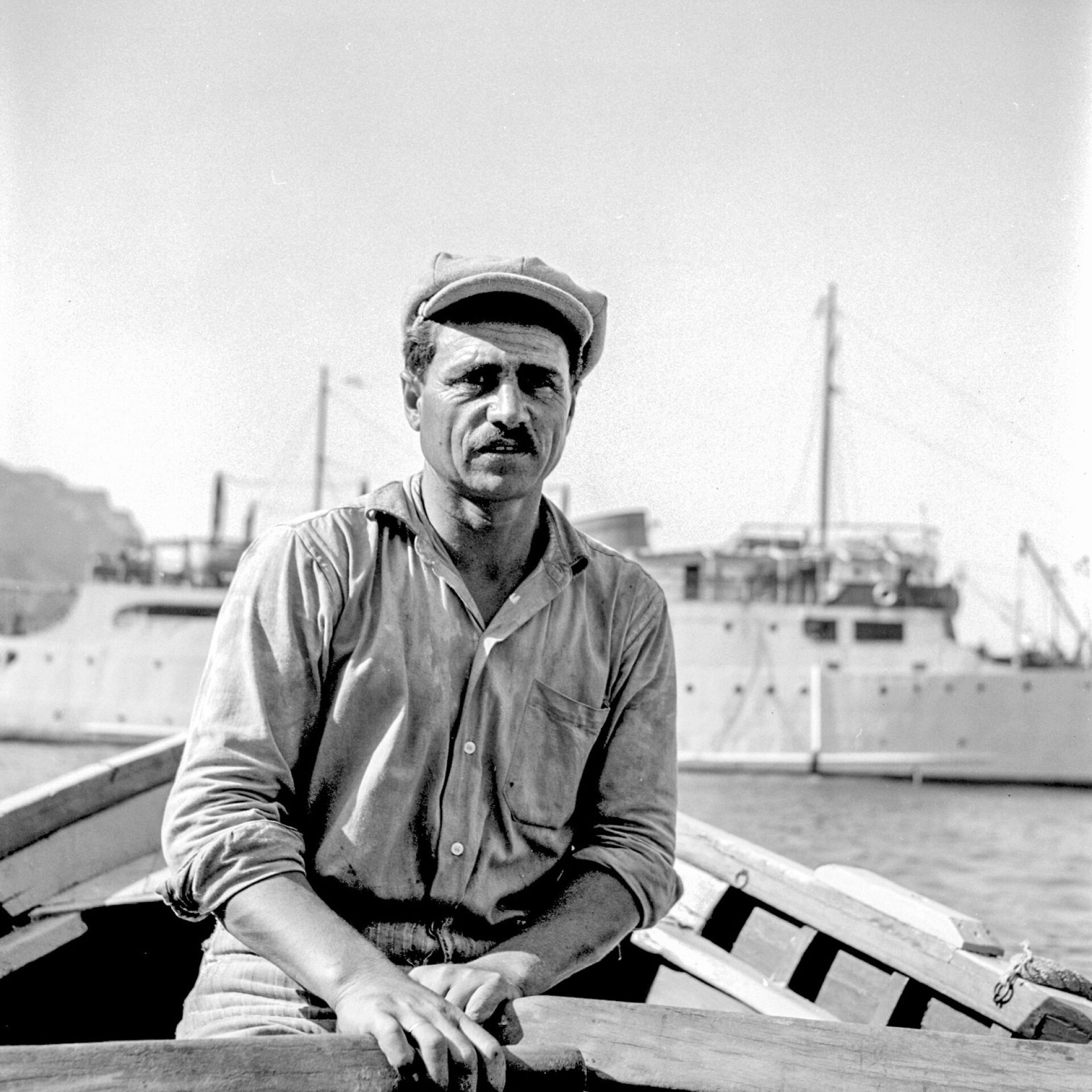 Λευτέρης Δακουτρός, ναύτης. Σαντορίνη. Πίσω του το θρυλικό πλοίο «Δέσποινα»