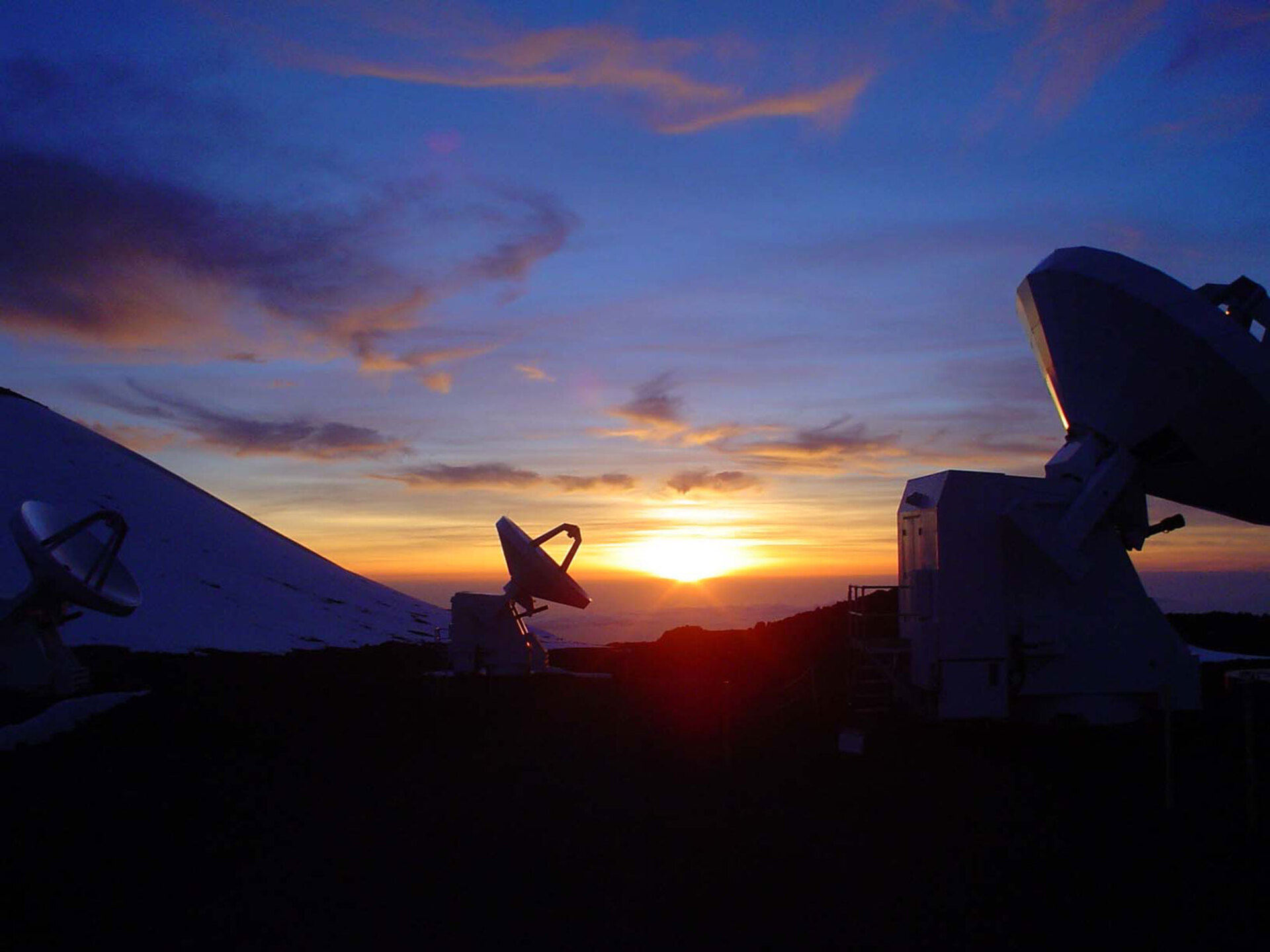 Μερικά από τα ραδιοτηλεσκόπια της SMA (κατασκευασμένη από Harvard/USA και πανεπιστήμια της Taiwan), έχουν αρχίσει τις παρατηρήσεις στα 4100 μέτρα του Mauna kea, καθώς δύει ο ήλιος στον Ειρηνικό Ωκεανό «ανάβοντάς» τη Δύση με χρώματα ιδιαίτερα στους Τροπικούς (τα ραδιοτηλεσκόπια. σε αντίθεση με τα οπτικά, μπορούν να παρατηρήσουν το Σύμπαν και την μέρα)