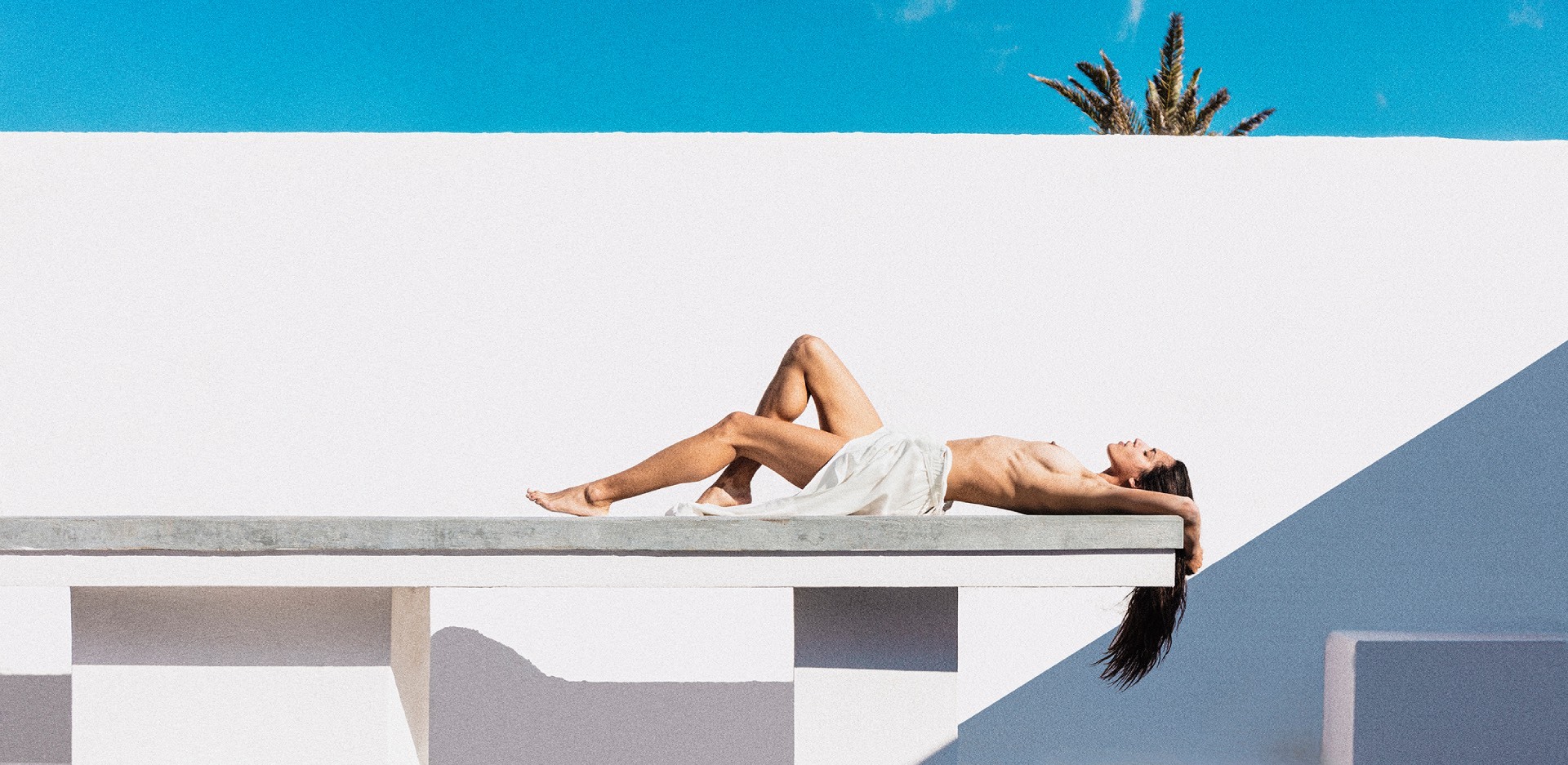 ημίγυμνη γυναίκα κάνει ηλιοθεραπεία