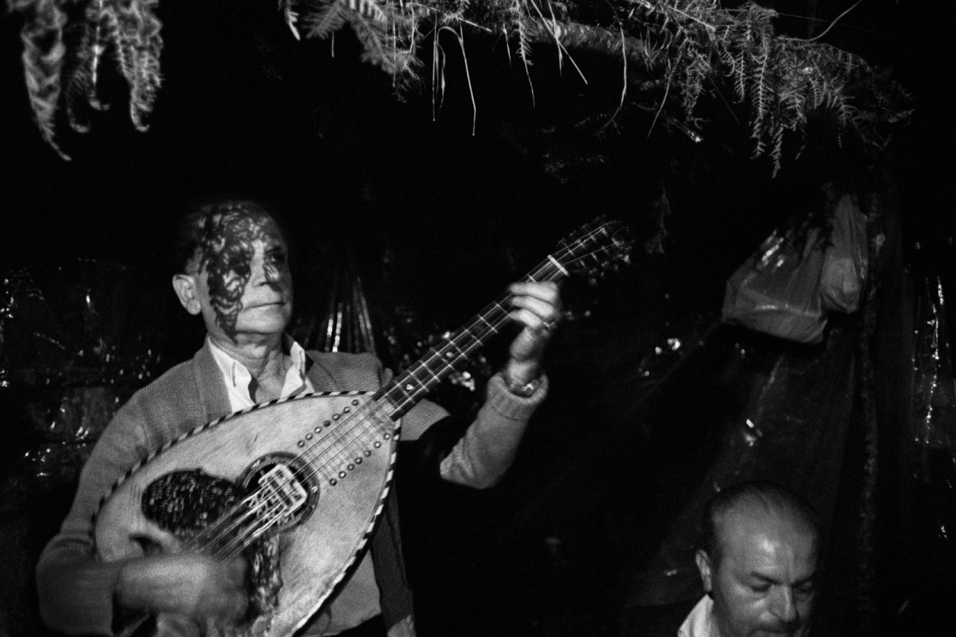 άντρας με κουστούμι που παίζει μουσικό όργανο σε πανηγύρι 