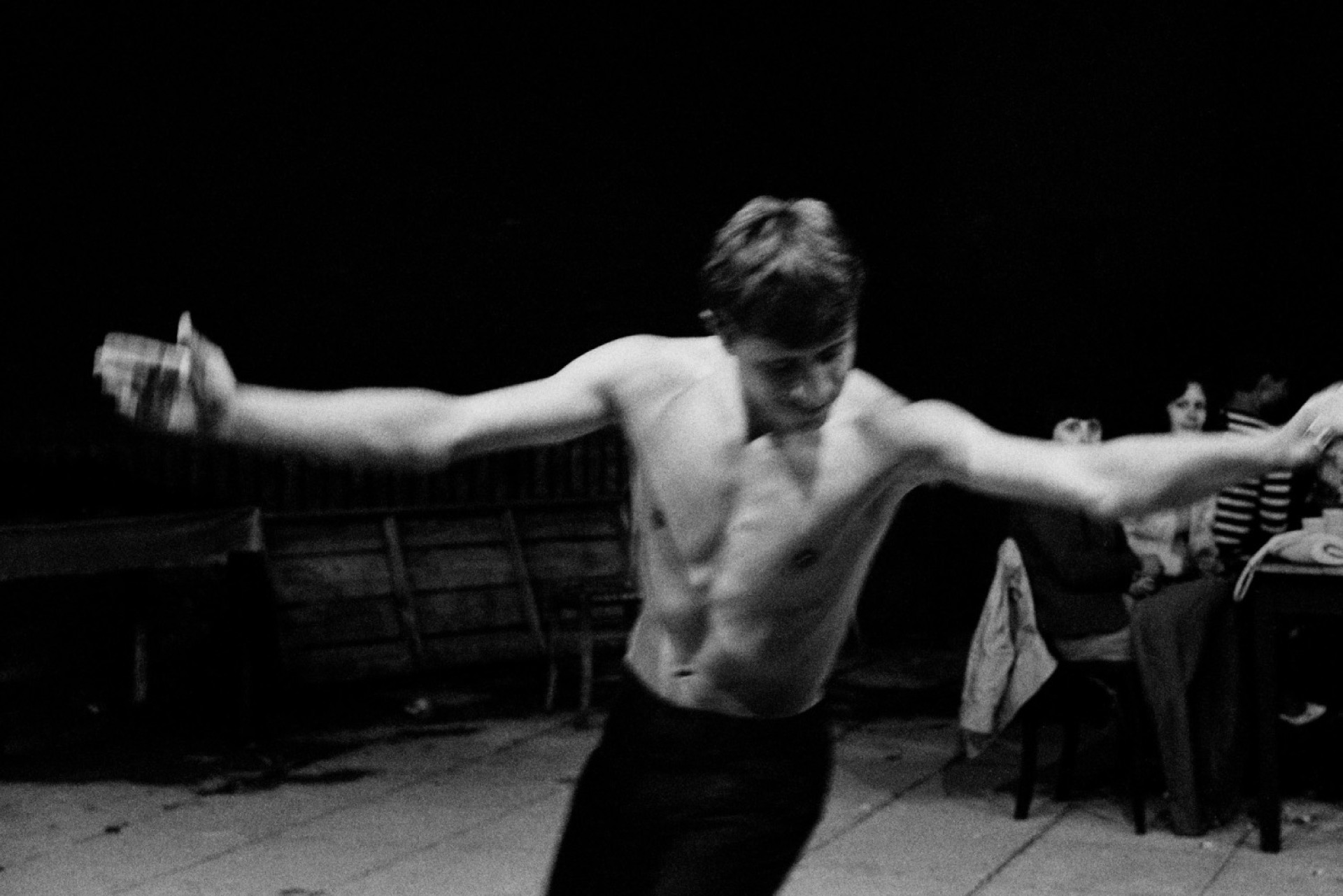 νεαρός άντρας χορεύει με ανοιχτά τα χέρια, χωρίς μπλούζα