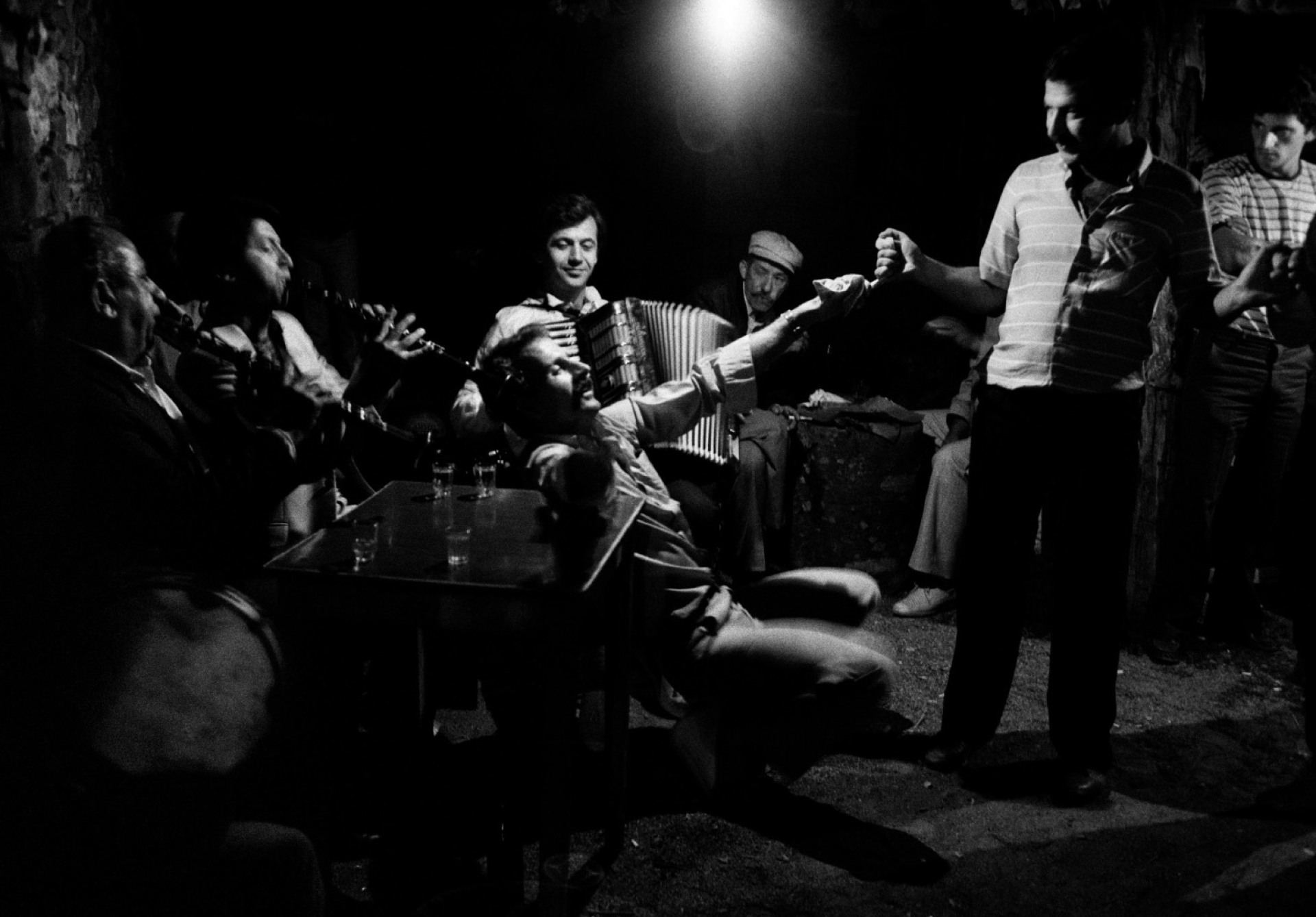 άντρες που παίζουν μουσική γύρω από άντρα που χορεύει