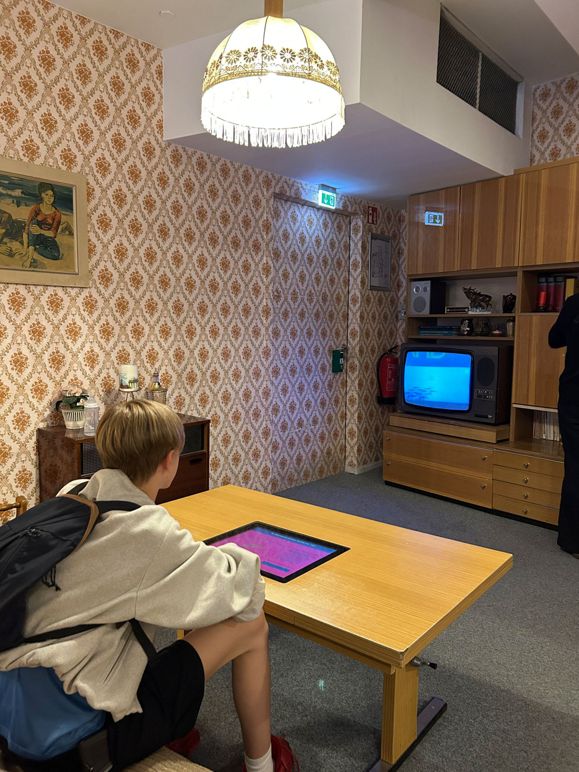 DDR Museum, αναπαράσταση ενός τυπικού καθιστικού σε διαμέρισμα της Ανατολικής Γερμανίας, με την πορτοκαλί ταπετσαρία και την τηλεόραση της εποχής