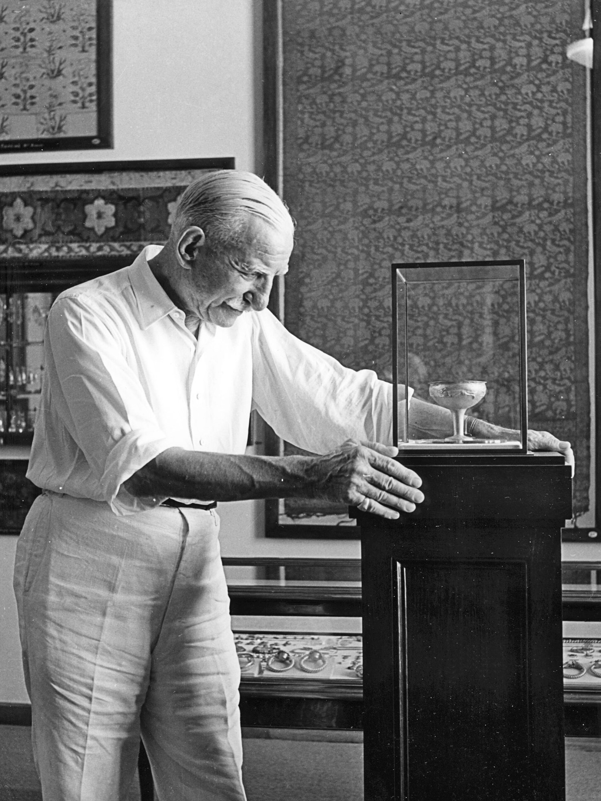 Ο Αντώνης Μπενάκης μπροστά από προθήκη με αρχαίο αγγείο, 1940-1950