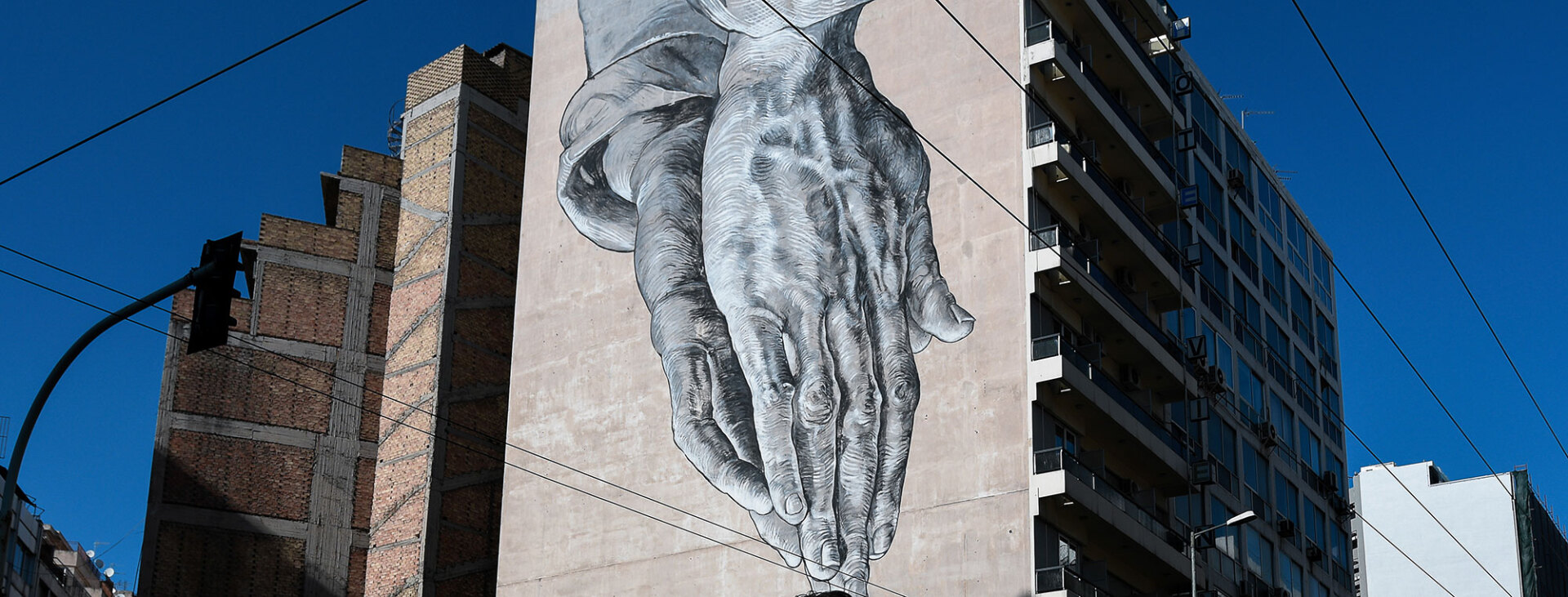 Το γκράφιτι «Praying for us» στην οδό Πειραιώς 20 © EUROKINISSI