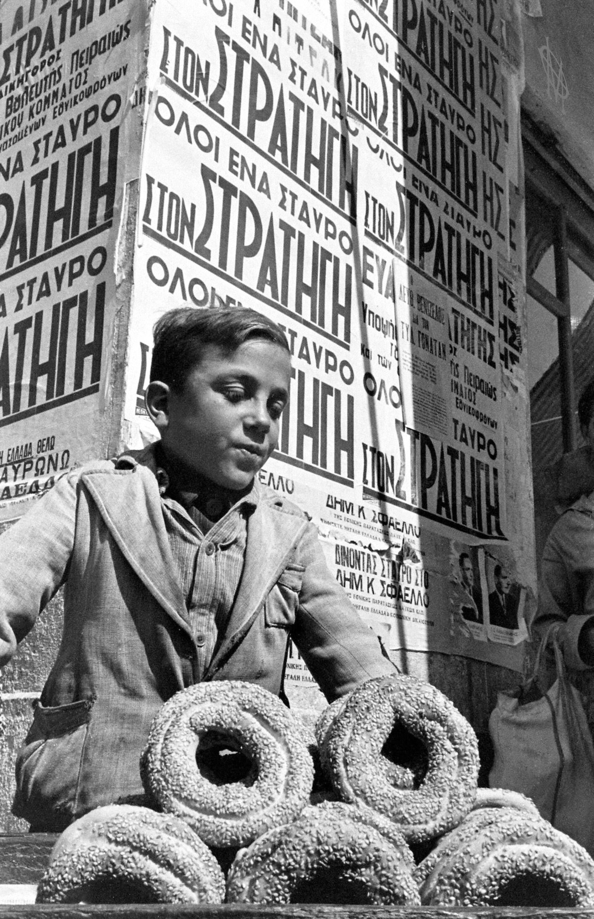 Νεαρός κουλουράς, Πειραιάς, Μάρτιος, 1946 | Ο κουλουρτζής, γνωστός και ως κουλουράς ή σιμιτζής, ήταν υπαίθριος μικροπωλητής που πουλούσε κουλούρια, το τουρκικό «σιμίτ»