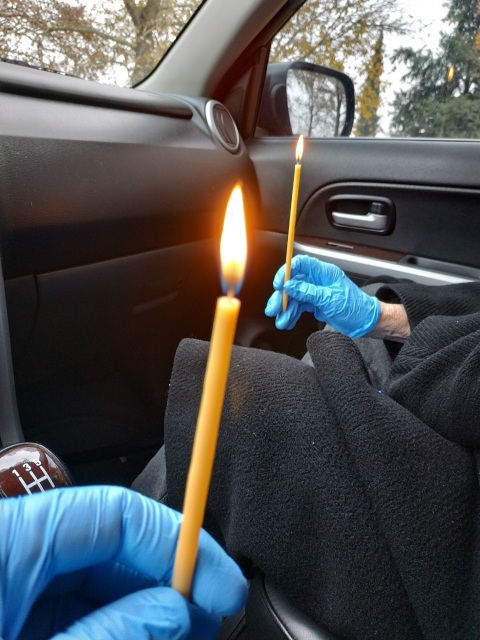 Χέρια που κρατούν αναμμένα κεριά μέσα σε αυτοκίνητο