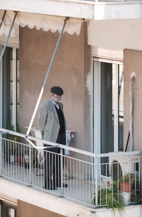 Ηλικιωμένος που φοράει μάσκα στο μπαλκόνι του