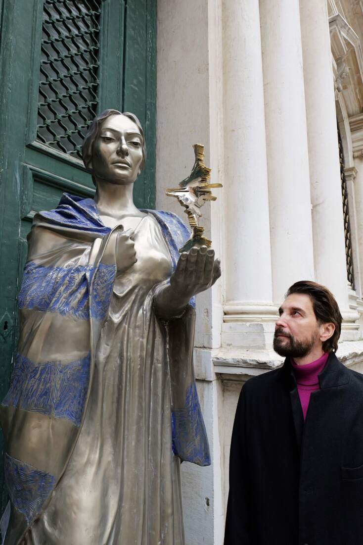 Αξίζει να σημειωθεί η λεπτομέρεια του γλυπτού, όπου κρατά στο χέρι της καρδιάς της,το μορφοποιημένο  ηχώγραμμά από την άρια Casta Diva, ως προσφορά.