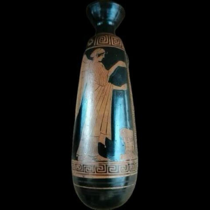 Αττικό ερυθρόμορφο αλάβαστρο. Στη μία όψη απεικονίζεται φτερωτή Νίκη μπροστά σε βωμό και στην άλλη νεαρή ανδρική μορφή στηριζόμενη σε βακτηρία. 