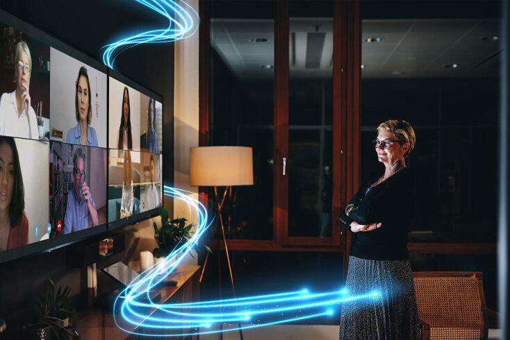 Γυναίκα στέκεται μπροστά από αναμμένη τηλεόραση