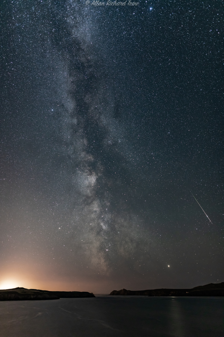  Allan Trow Perseid: Εικόνα ενός διάττοντα αστέρα από βροχή Περσείδων πάνω από το Πεμπρόκσιρ της Ουαλίας. Το μετέωρο είναι ορατό κάτω δεξιά και ο Γαλαξίας μας είναι ορατός στο κέντρο σαν νεφώδης ζώνη