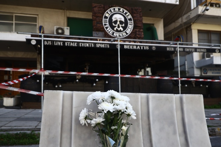 Λίγα λουλούδια έξω από το μπαρ όπου δολοφονήθηκε ο 32χρονος αστυνομικός στη Θεσσαλονίκη