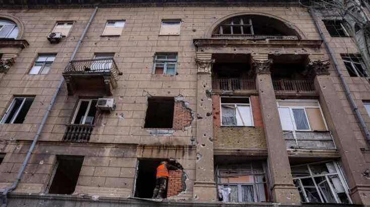 Εργάτες κλείνουν με τούβλα τις τρύπες από τους βομβαρδισμούς