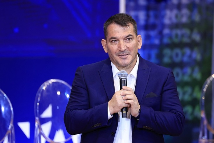 Ο Πύρρος Δήμας μιλάει όρθιος κρατώντας μικρόφωνο