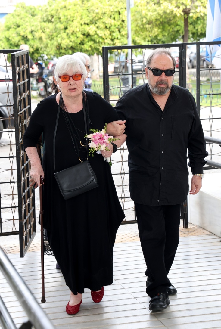 Η Ξένια Καλογεροπούλου συνοδευόμενη από τον Σταμάτη Φασουλή στην κηδεία του Γιάννη Φέρτη