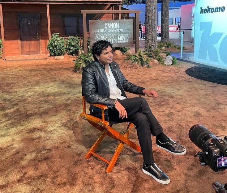 Ο Νάιτ Σιάμαλαν καθισμένος δίνει συνέντευξη