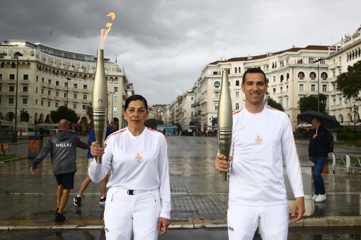 2 λαμπαδηδρόμοι κρατώντας την ολυμπιακή φλόγα 
