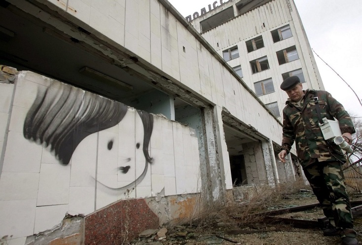 Άνδρας περπατάει μπροστά από τοίχο με ζωγραφιά ένα πρόσωπο παιδιού