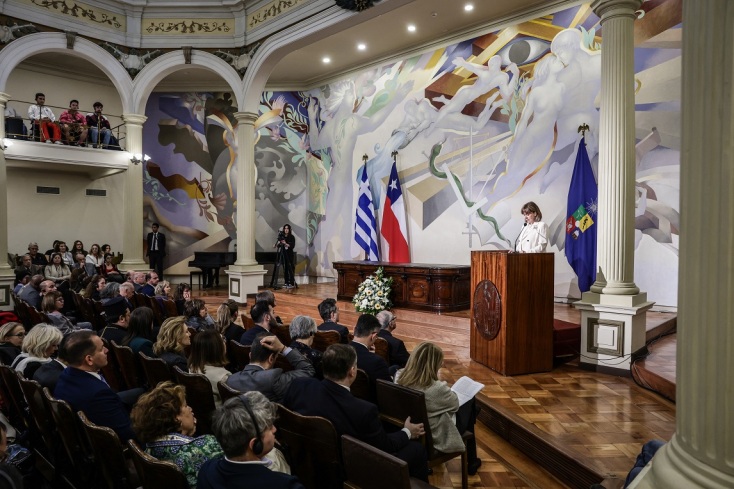 Η Πρόεδρος της Δημοκρατίας Κατερίνα Σακελλαροπούλου μιλάει όρθια στο βήμα μπροστά από καθισμένους