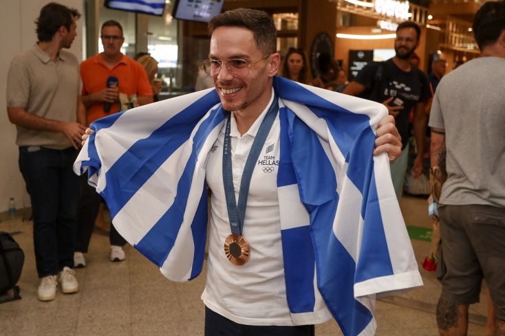 Ο Λευτέρης Πετρούνιας με την ελληνική σημαια