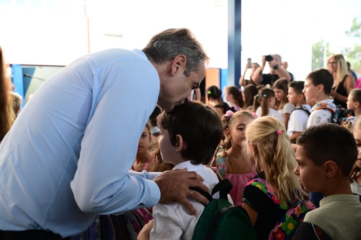 Ο Κυριάκος Μητσοτάκης φιλά στο κεφάλι μικρό μαθητή κατά τη διάρκεια του αγιασμού σε σχολείο της Γλυφάδας