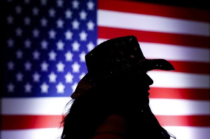 Γυναίκα με καπέλο μπροστά από την αμερικανική σημαία