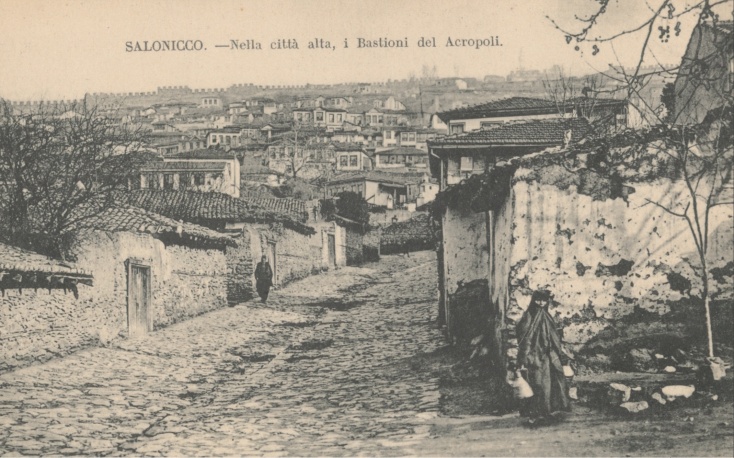 Δρόμος της παλαιάς Θεσσαλονίκης με φόντο την Άνω Πόλη, σε καρτ-ποστάλ των αρχών του 20ου αιώνα.