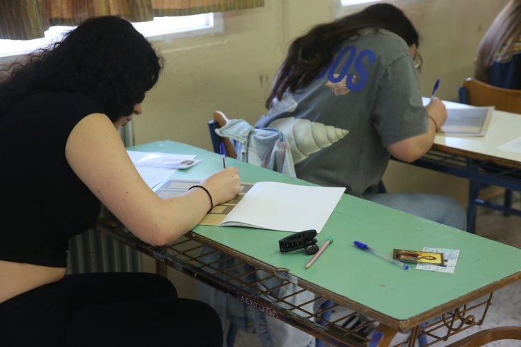 Υποψήφιοι γράφουν τα στοιχεία τους στο τετράδιο απαντήσεων